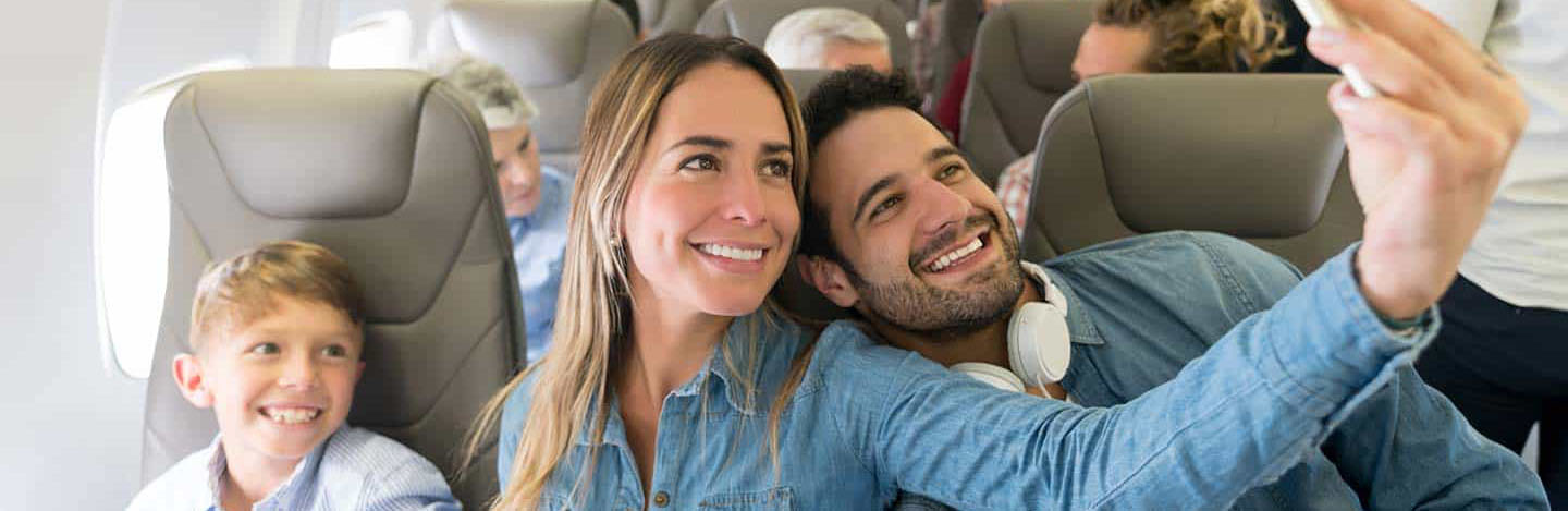 Gezin dat ontspannen in het vliegtuig zit, passend bij comfortabel luchthavenvervoer.